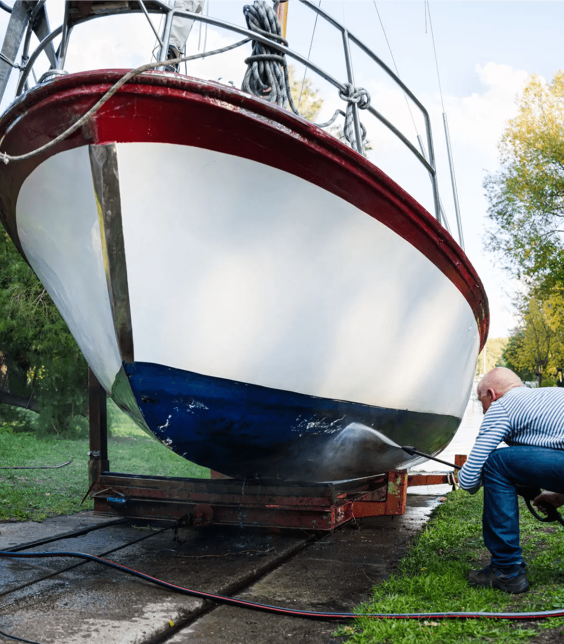 Person power-washing a boat bottom